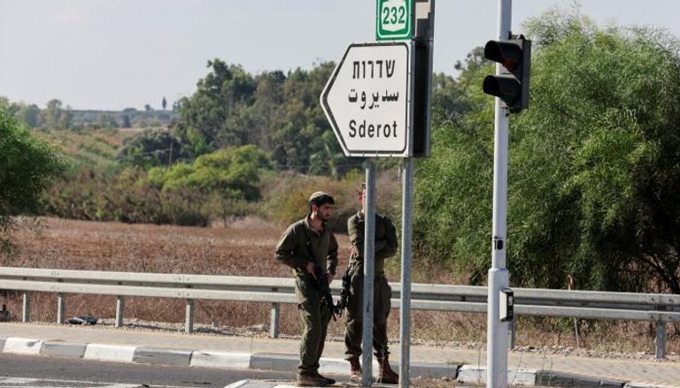جنديان إسرائيليان يقفان في سديروت بغلاف غزة
