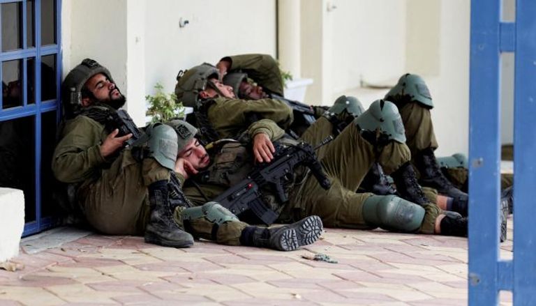 جنود إسرائيليون يستريحون قرب مبنى في يوم الهجوم