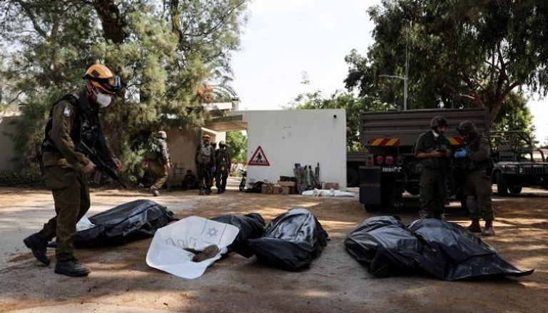 جنود إسرائيليون قرب جثث قتلى هجمات حماس - رويترز