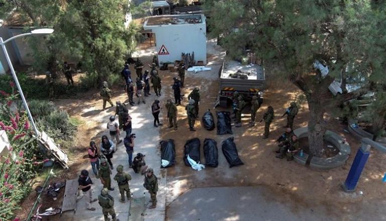 جنود إسرائيليون حول جثث بعض قتلاهم - رويترز