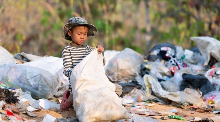 طفل يقرأ وسط القمامة