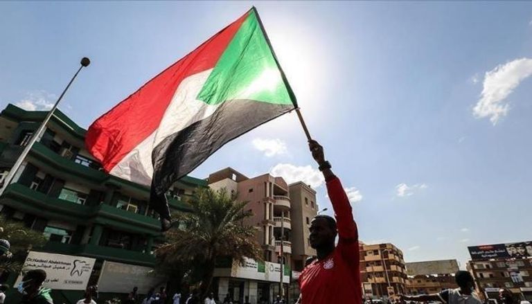 مواطن سوداني يحمل علم بلاده -أرشيفية