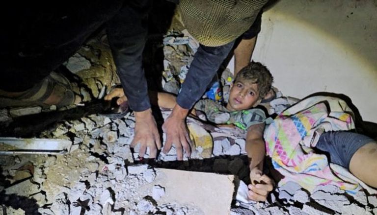 إنقاذ طفل فلسطيني من تحت أنقاض منزل دمرته غارة إسرائيلية بغزة
