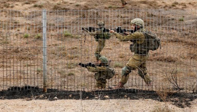 جنود إسرائيليون يقومون بمسح منطقة بينما تنطلق صفارات الإنذار في إسرائيل
