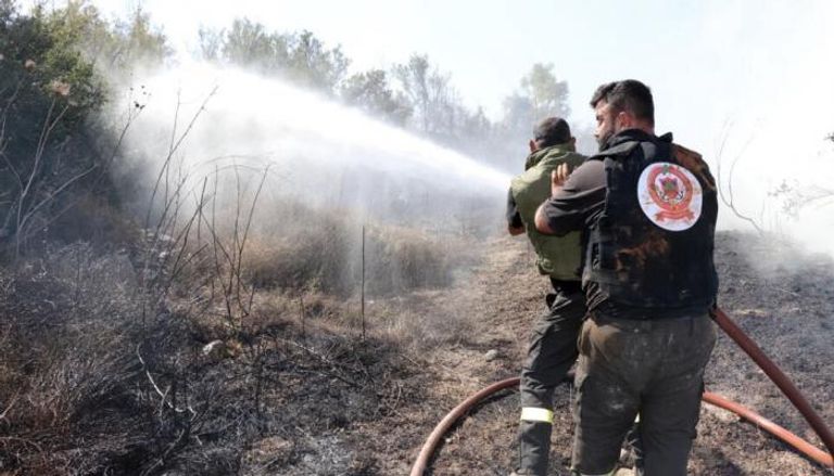 عناصر من الدفاع المدني اللبناني يطفئون حريقا بسبب قصف إسرائيلي