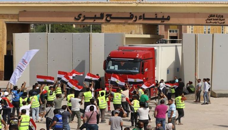 عمال إغاثة يحتفلون بعودة شاحنة لمصر عبر معبر رفح بعد أن أفرغت حمولتها بقطاع غزة