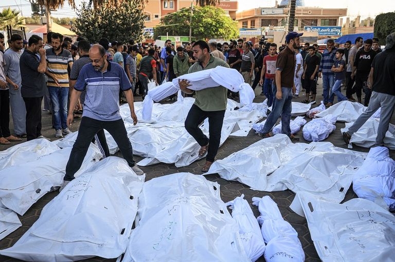 فلسطينيان يبكيان على أنقاض منزلهما بعد قصفه بغزة