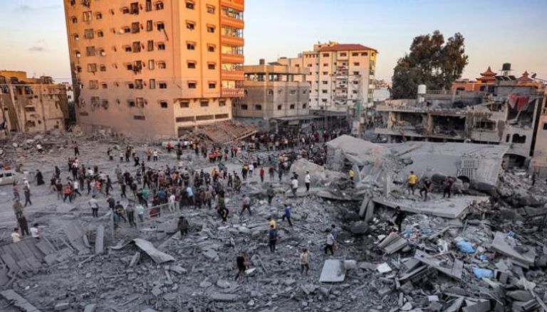 أشخاص يبحثون بين الأنقاض عن الناجين وجثث الضحايا في أعقاب قصف إسرائيلي جنوب غزة