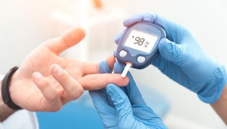 مختص يقيس مستوى السكر في الدم لمريض