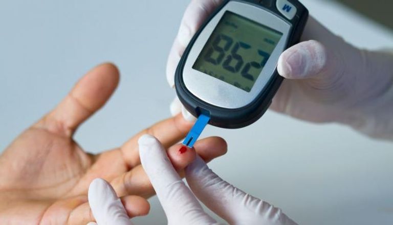مختص يقيس مستوى السكر في الدم لمريض