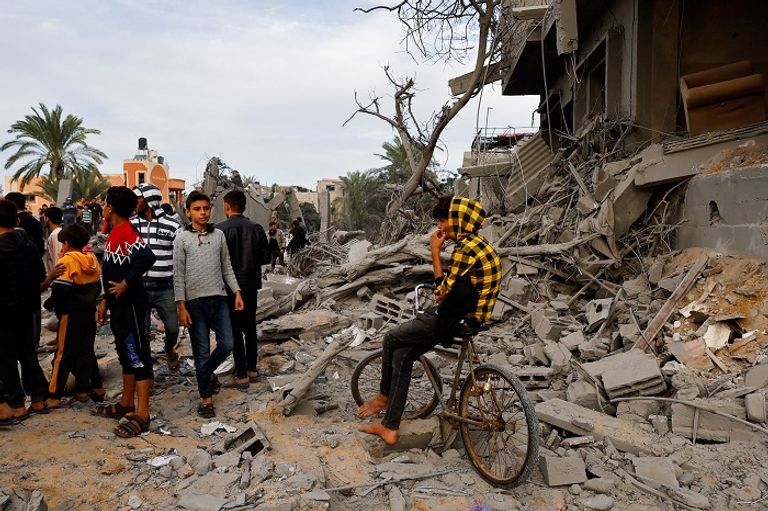أطفال فلسطينيون على أنقاض منزل دمرته غارة إسرائيلية على غزة النيران تتصاعد جراء غارة إسرائيلية على غزة - رويترز