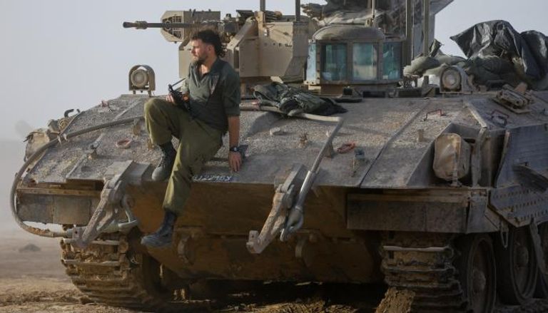 جندي إسرائيلي جالس فوق دبابة في قطاع غزة خلال أيام الهدنة