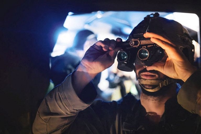 جندي إسرائيلي في قطاع غزة سيدة فلسطينية وابنتها في قطاع غزة - رويترز