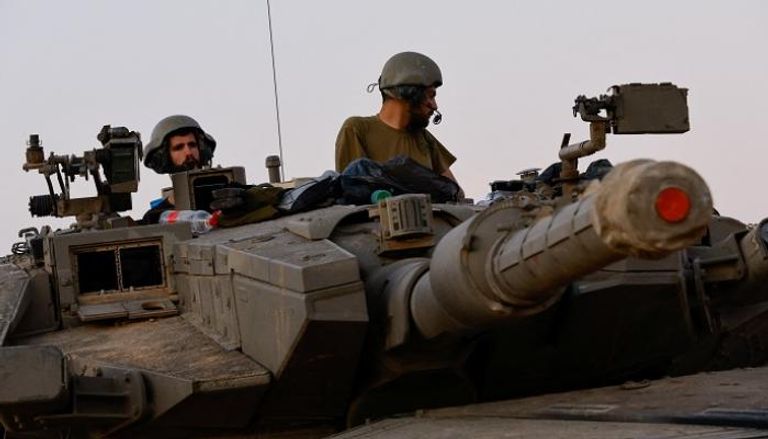 جنديان إسرائيليان فوق دبابة قرب غزة - رويترز