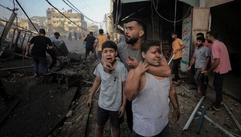 فلسطينيون عقب غارة إسرائيلية على قطاع غزة - رويترز