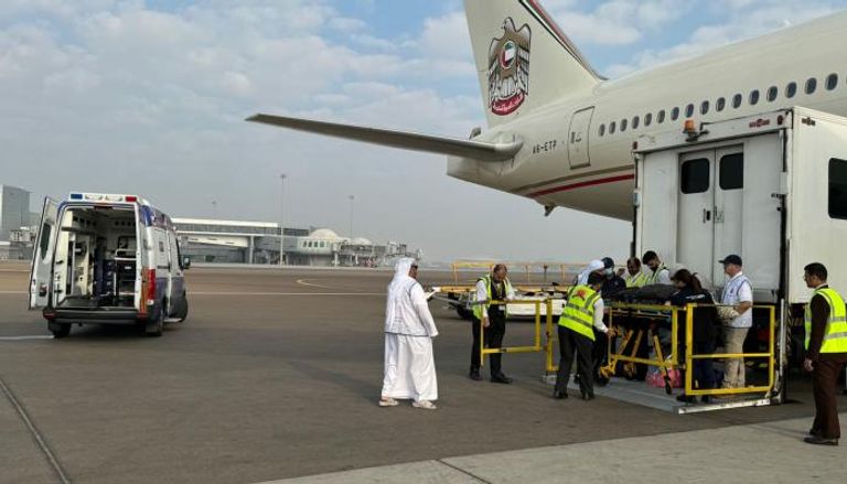 نقل الأطفال الجرحى والمرضى من الطائرة لسيارة الإسعاف بمطار أبوظبي 