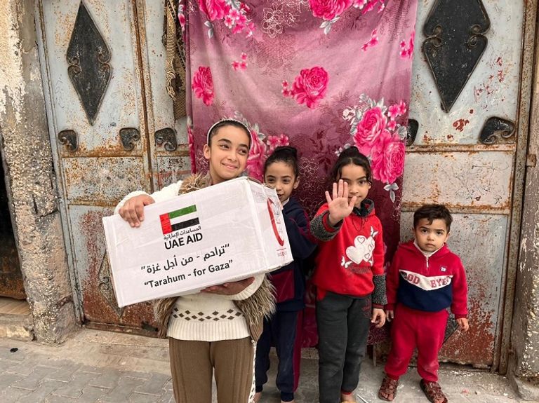 أسرة فلسطينية تتسلم طردا من الهلال الأحمر الإماراتي