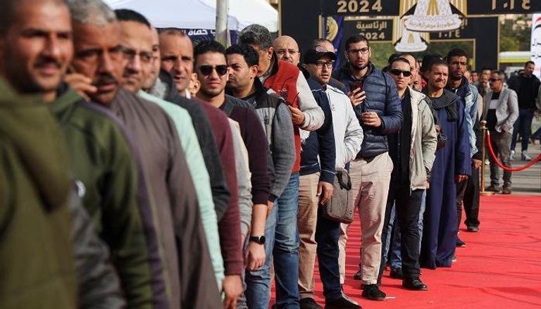 ناخبون مصريون في طابور أمام لجنة انتخابية بالقاهرة - رويترز