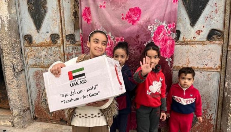 أطفال رفح يحملون بعض المساعدات الإماراتية