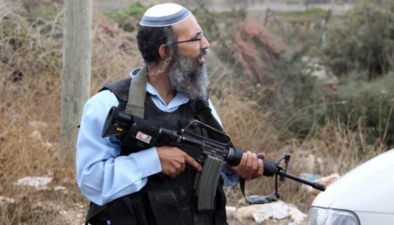 مستوطن إسرائيلي يحمل بندقية 