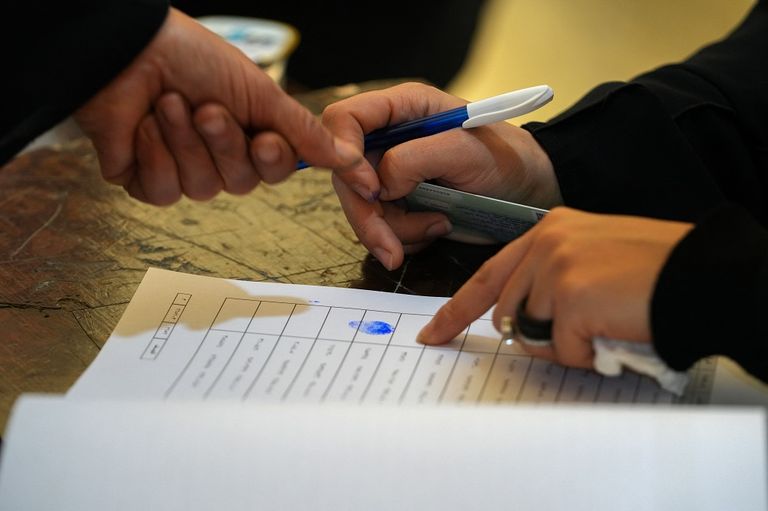 أحد المصوتين يغمس إصبعه في الحبر