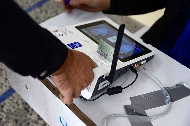 أحد المصوتين يغمس إصبعه في الحبر