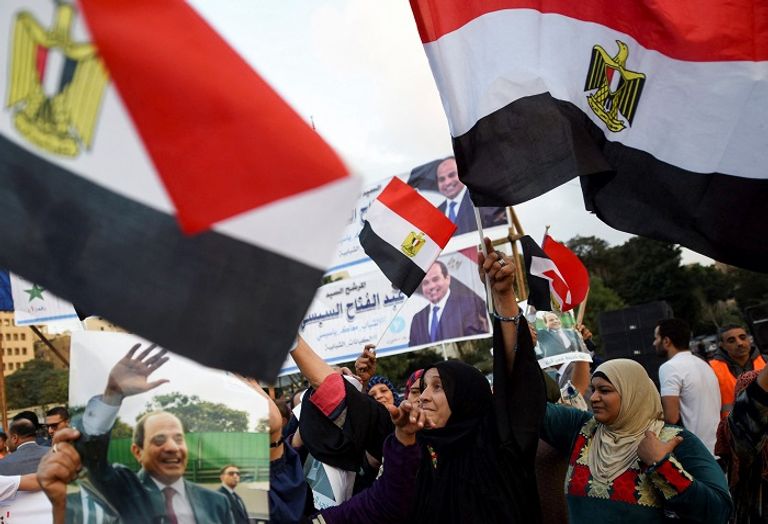 مواطن مصري يحمل صورة الرئيس السيسي - رويترز