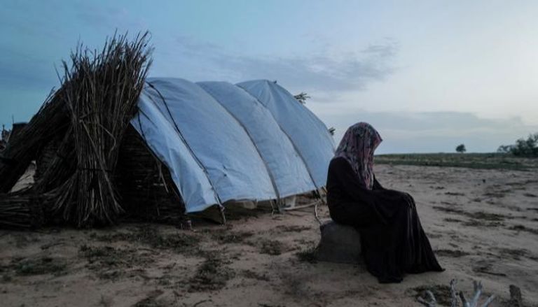 نازحة سودانية تجلس قرب خيمة - رويترز