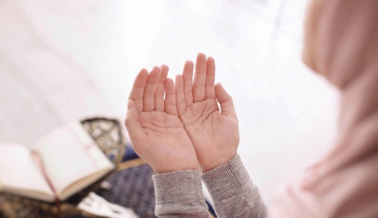 شخص يرفع يديه بالدعاء- أرشيفية