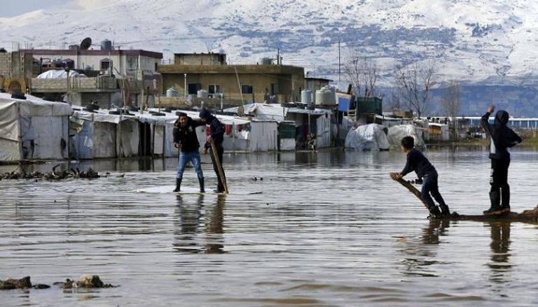 أطفال يلهون بمياه الأمطار في لبنان