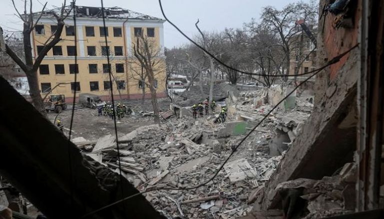 عمال يعملون في موقع مبنى سكني دمرته ضربة صاروخية روسية بأوكرانيا - رويترز 