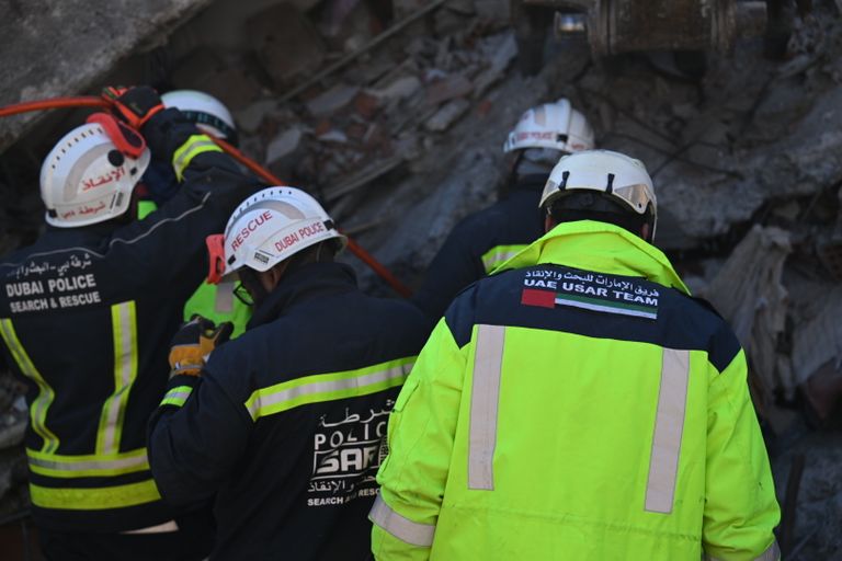 أحد عناصر فريق الإنقاذ الإماراتي يحمل طفلة سورية بعد إنقاذها