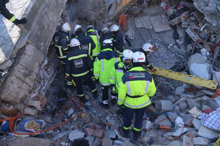 أحد عناصر فريق الإنقاذ الإماراتي يحمل طفلة سورية بعد إنقاذها