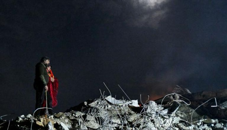 رجل وامرأة يرقبان ركام منزل دمره الزلزال