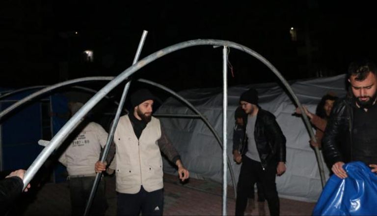 عبدو الحموي يبني خيمة مع مجموعة من المتطوعين