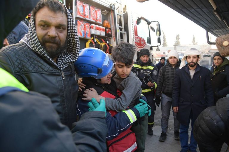 إماراتية تحمل طفلا سوريا بعد إنقاذه من تحت الأنقاض في تركيا