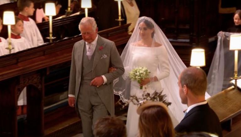 الملك تشارلز ممسكا بيد ميغان في حفل زفافها على هاري