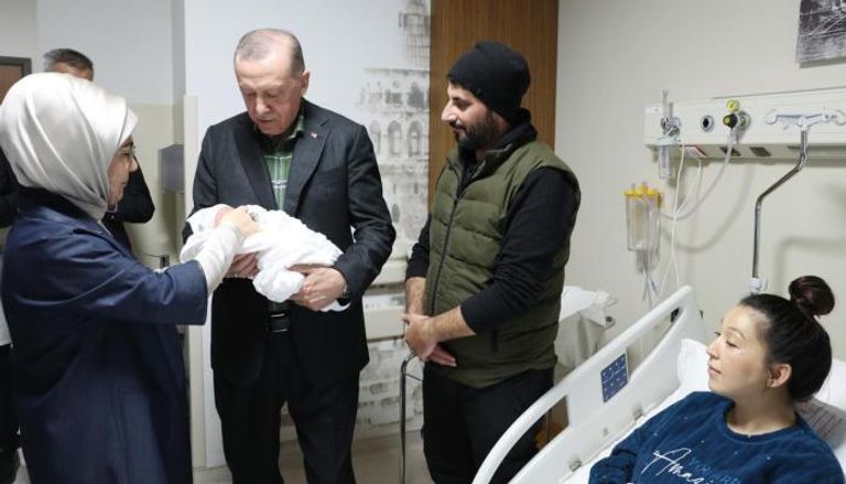أردوغان يحمل رضيع إحدى المصابات