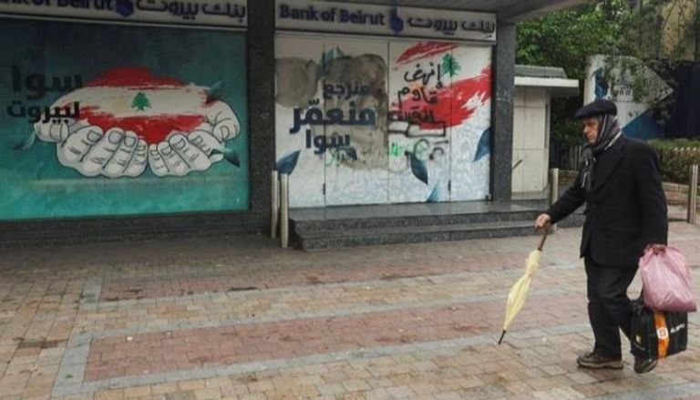 لبناني يمر أمام فرع مغلق لبنك بيروت في صيدا- رويترز