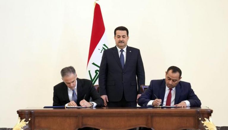 وزير الكهرباء العراقي مع مدير شركة جنرال إلكتريك خلال التوقيع