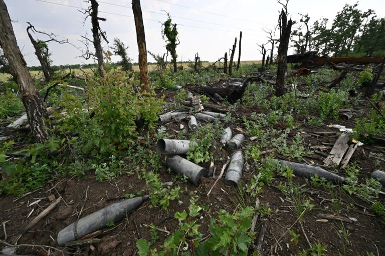 امرأة قرب قذائف مدفعية ملقاة في قرية أوزيرنو بمنطقة كييف