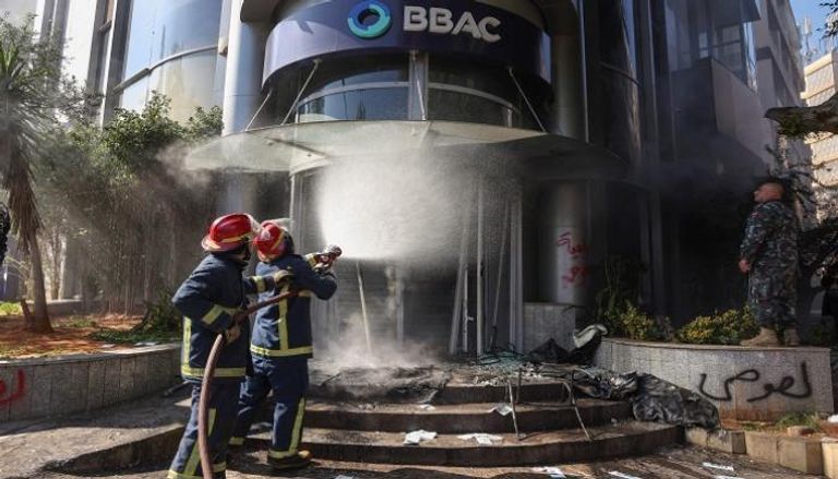 رجال الإطفاء يرشون الماء على بنك BBAC محترق خلال احتجاجات بيروت  - رويترز