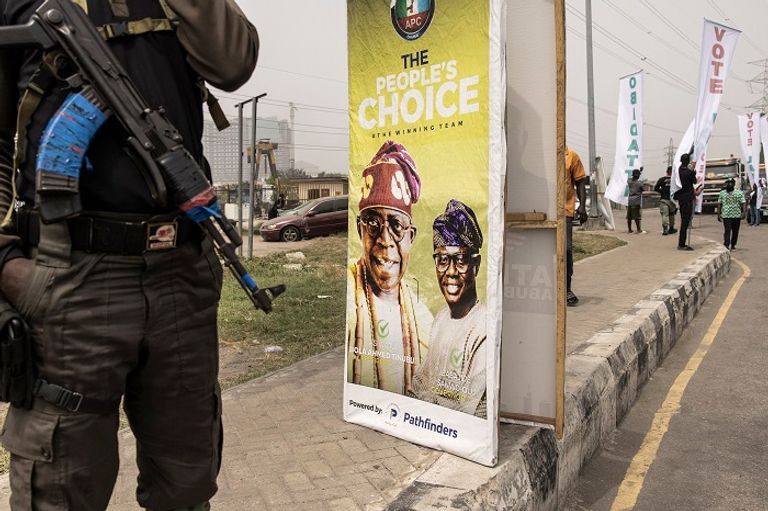 جندي نيجيري بجوار ملصق دعائي للانتخابات الرئاسية مواطنان نيجيريان أمام لافتات دعائية لمرشحي الرئاسة