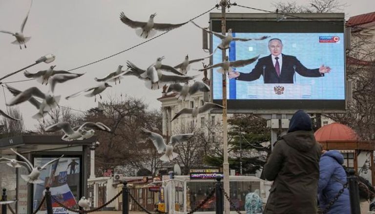بوتين يظهر على شاشة أثناء خطابه أمام البرلمان الروسي- رويترز