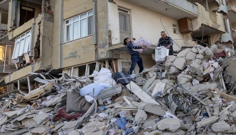 مواطنان تركيان في هاتاي يأخذان متعلقاتهما من شقتهما المدمرة في أعقاب الزلزال 