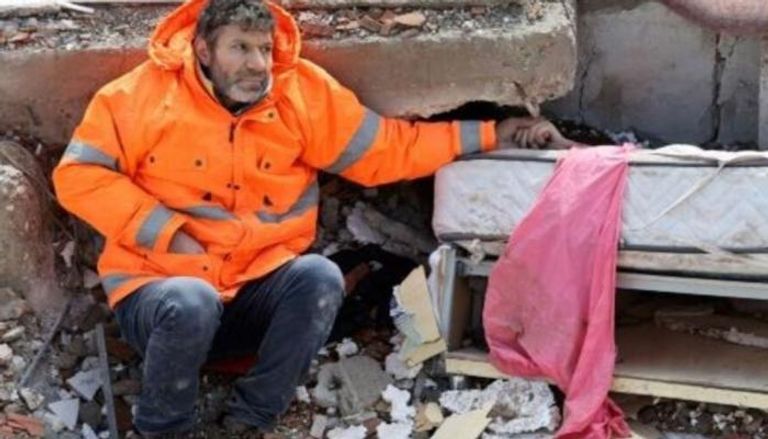 مسعود هانسر يمسك بيد ابنته المتوفاة إرماك في أعقاب الزلزال
