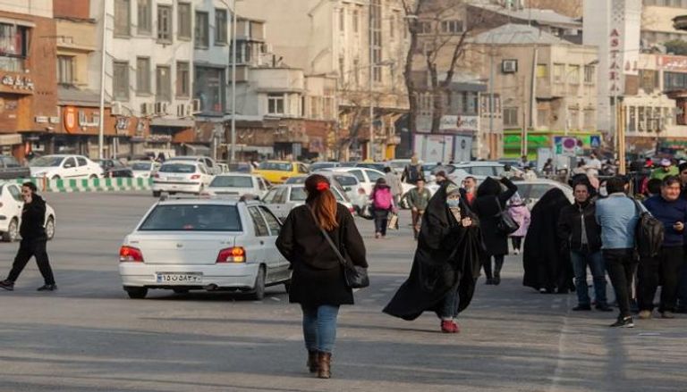 سيدة تمشي حاسرة الرأس في شوارع طهران تحديا لقانون الحجاب الإلزامي