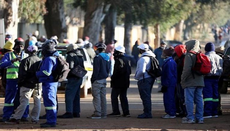 أشخاص يبحثون عن عمل خارج موقع بناء في جنوب أفريقيا - رويترز