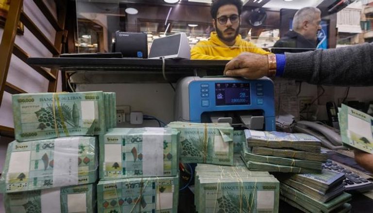 رجل يعد الأوراق النقدية بالليرة اللبنانية في محل للصرافة في بيروت