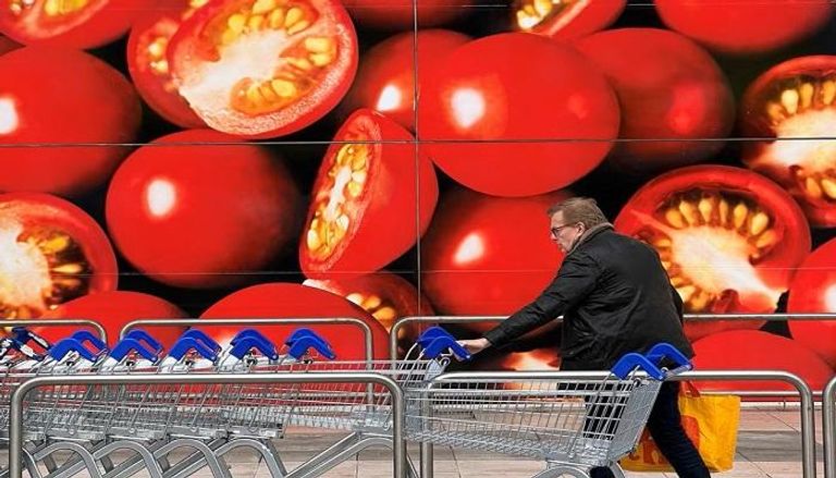 متسوق بجوار صورة للطماطم في ماركت تيسكو - رويترز